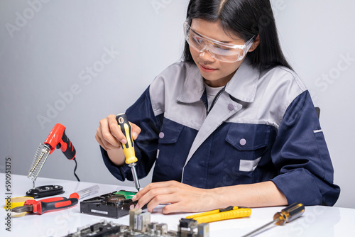 Bilde på lerret Female professional repair engineer repairing electronic circuit board of computer on her desk