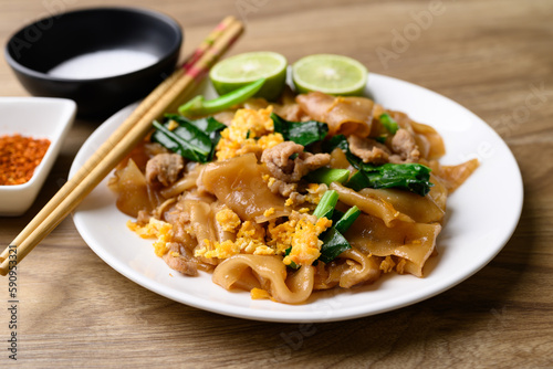 Thai food (Pad See Ew), Stir fried rice noodles soy sauce with pork, egg and kale on wooden background
