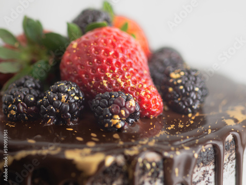 chocolate frosted dripped icing cup cake with sweet fruit topping and golden brush strokes photo