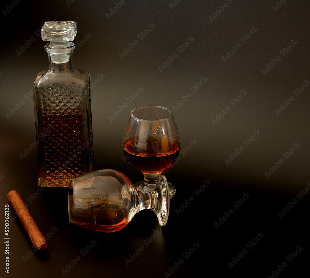 Cuban cigar, crystal decanter and two glasses of whiskey on a black background. Cuban cigar, crystal decanter and two glasses of whiskey on a black background.