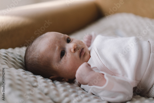 Portrait of a 1 month old baby. Cute newborn baby lying on a developing rug. Love baby. Newborn baby and mother. photo