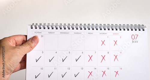 Foto Desk calendar with ticks and crosses, depicting four day work week concept