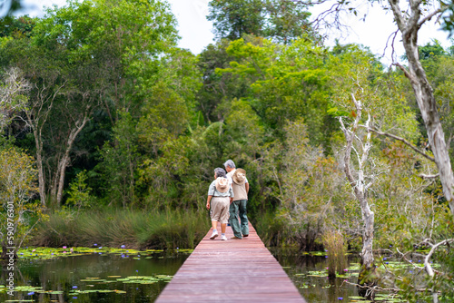 Happy Asian senior couple walking on wooden bridge during hiking together at tropical forest. Retired elderly people man and woman enjoy outdoor lifestyle travel nature on summer holiday vacation. © CandyRetriever 