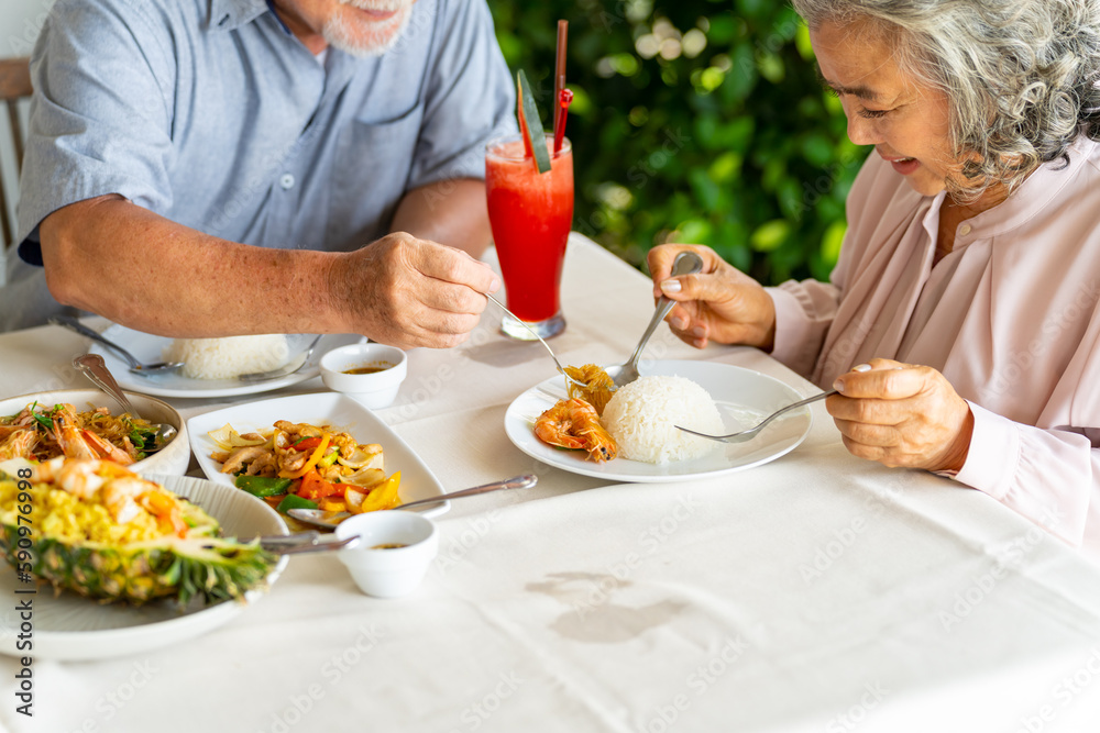 Happy Asian family senior couple having lunch and sharing meal together at restaurant. Elderly people man and woman enjoy retirement with outdoor activity lifestyle on summer holiday travel vacation. Happy Asian family senior couple having lunch and sharing meal together at restaurant. Elderly people man and woman enjoy retirement with outdoor activity lifestyle on summer holiday travel vacation.