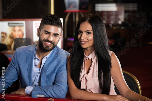 Two Fashionable Couple Behind Table in a Casino