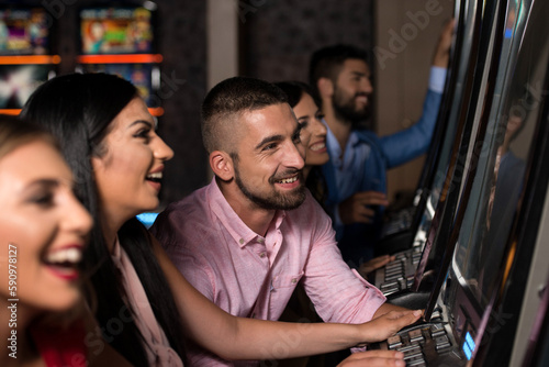 Happy Friends Playing Arcade Machine in a Casino