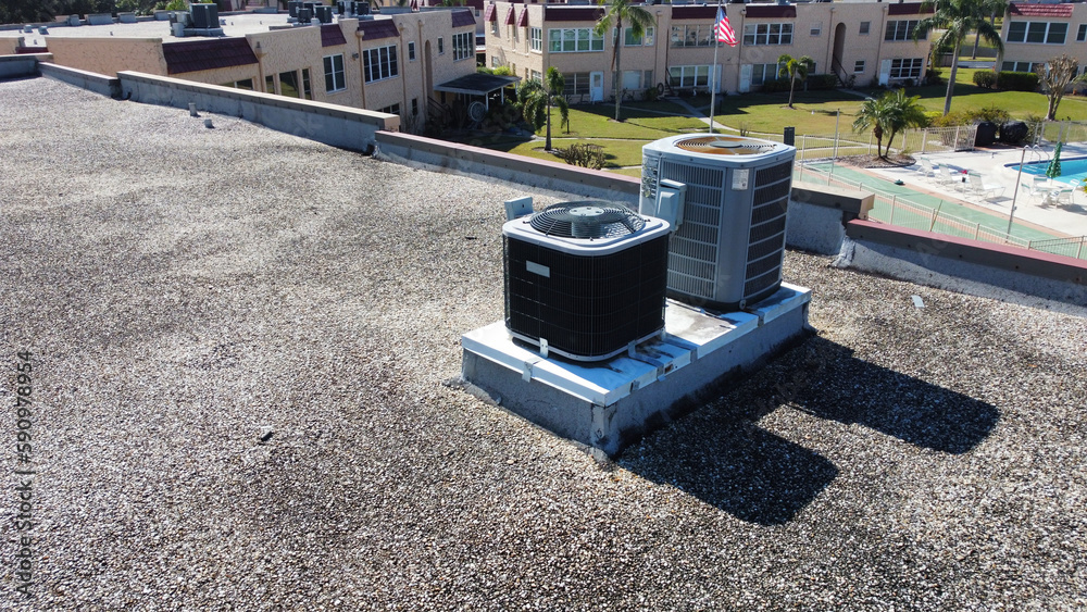 Air conditioning units on apartment roof top for central air for condos in Florida from aerial drone Air conditioning units on apartment roof top for central air for condos in Florida from aerial drone