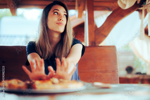 Unhappy Woman refusing to Eat her Pizza Dish in a Restaurant. Disgruntled customer not liking the meal sending it back
