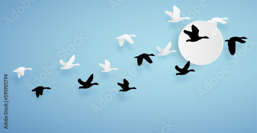 duck or teal birds flying to the sky on blue background and sun. paper art concept.