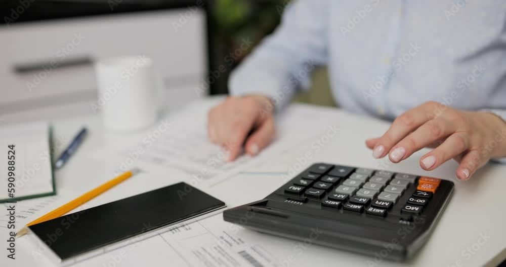 Woman using calculator for calculate domestic bills at home