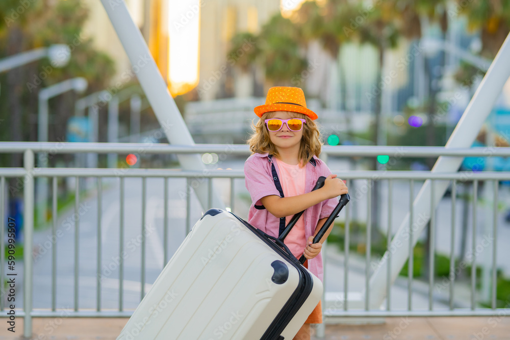 Child with suitcase going on vacation. Tourist boy on holiday, travel kids concept. Travel and adventure. Cute boy with suitcase on city street background. Child with suitcase going on vacation. Tourist boy on holiday, travel kids concept. Travel and adventure. Cute boy with suitcase on city street background.