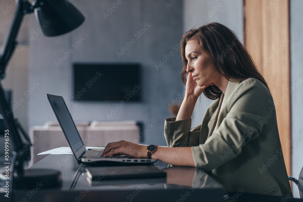 Focused businesswoman working in the office with a laptop Focused businesswoman working in the office with a laptop
