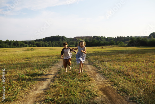 Children walk in the summer in nature. Child on a sunny spring morning in the park. Traveling with children. © alexkich
