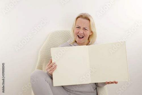 Older woman holding white cardboard. High quality photo photo