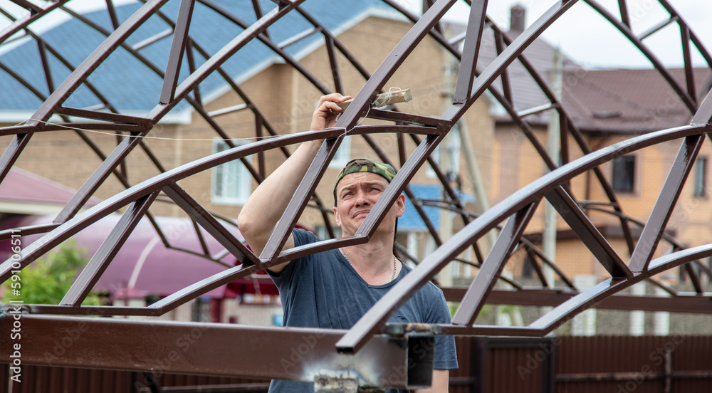 The worker installs the metal on the canopy.