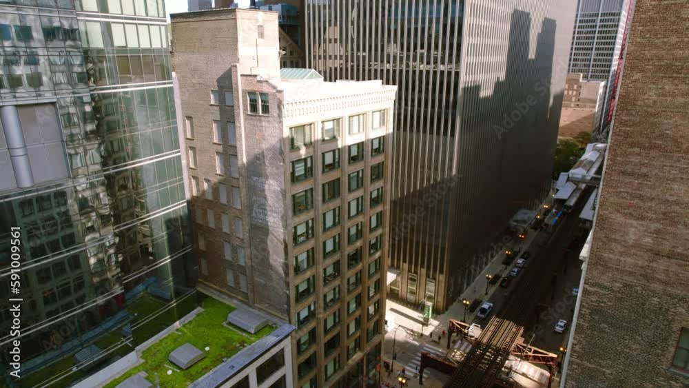 reveal drone shot of the CTA train line in Chicago between buildings reveal drone shot of the CTA train line in Chicago between buildings