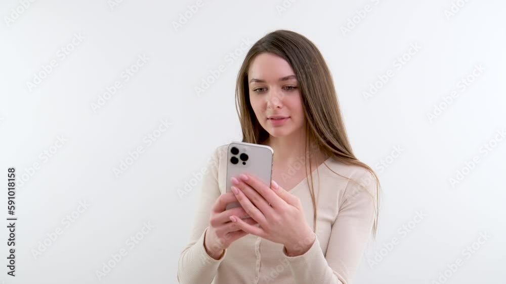 Young woman using cellphone, swiping and texting message, grey background. High quality 4k footage Young woman using cellphone, swiping and texting message, grey background. High quality 4k footage