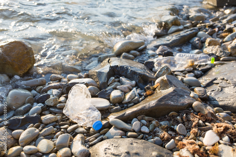 plastic pollution of Black sea. old crumpled bottle on coast. environmental protection plastic pollution of Black sea. old crumpled bottle on coast. environmental protection