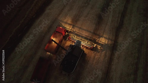Aerial shot at night harvester gathering crops from agricultural fields. Global food crisis and grain supply chains