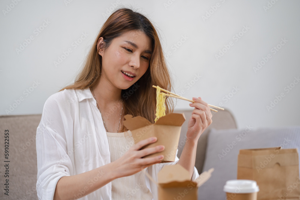 Asian woman with takeaway food and drinks at home. consumption eating home delivery food. enjoying delicious takeaway delivery tasty meal Asian woman with takeaway food and drinks at home. consumption eating home delivery food. enjoying delicious takeaway delivery tasty meal