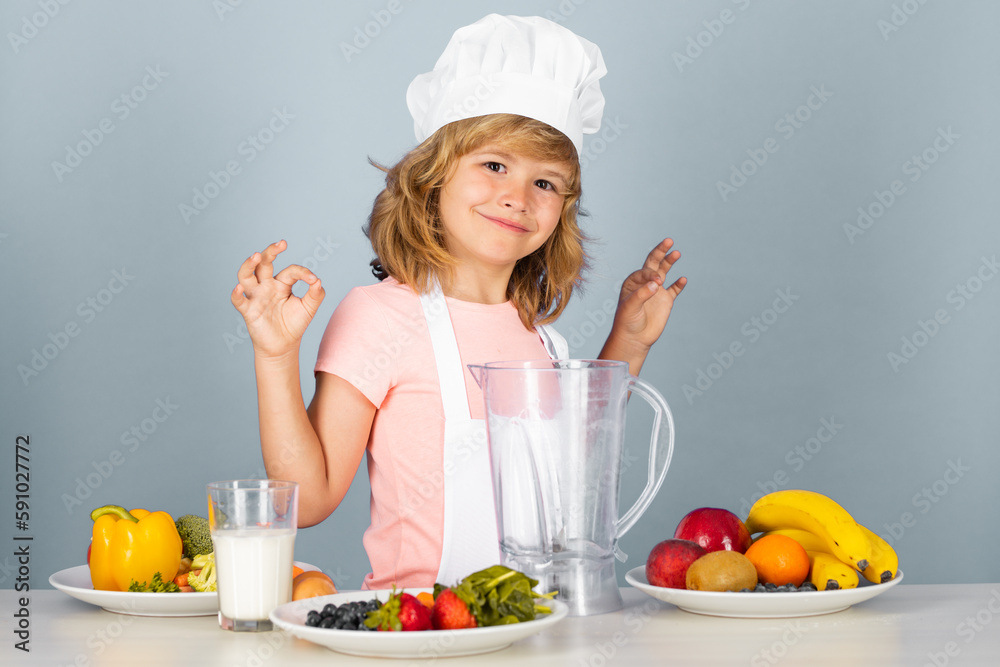 Cooking children. Chef kid boy making fresh vegetables for healthy eat. Portrait of little child in form of cook isolated on grey background. Kid chef. Fruits and vegetables for kids. Cooking children. Chef kid boy making fresh vegetables for healthy eat. Portrait of little child in form of cook isolated on grey background. Kid chef. Fruits and vegetables for kids.