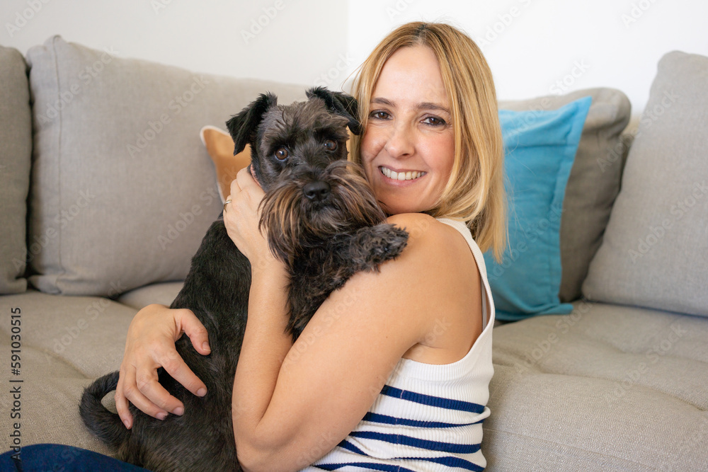Young woman with her cute schnauzer at home. Lovely pet Young woman with her cute schnauzer at home. Lovely pet