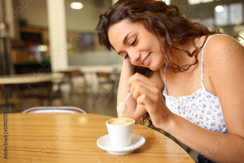Candid woman stirring coffee in a restaurant