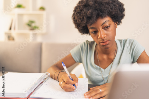 Young black woman taking notes in her notebook