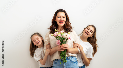 Daughters giving mother bouquet of flowers. photo