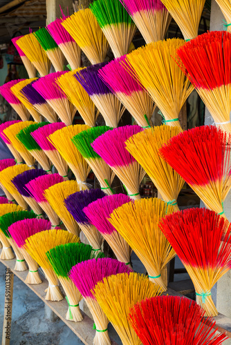 Close up of colourful stacks of incense sticks lined up in rows