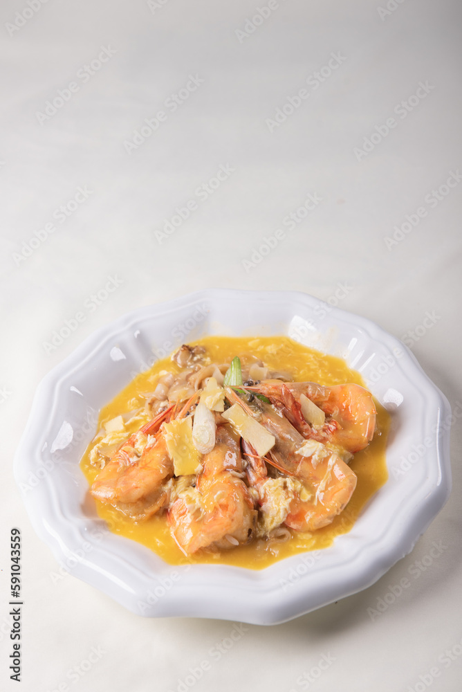 braised wok fried giant fresh tiger prawn with hot fun rice noodle and vegetables in golden yellow chicken stock cheese sauce on wood table asian Chinese halal seafood banquet menu for restaurant