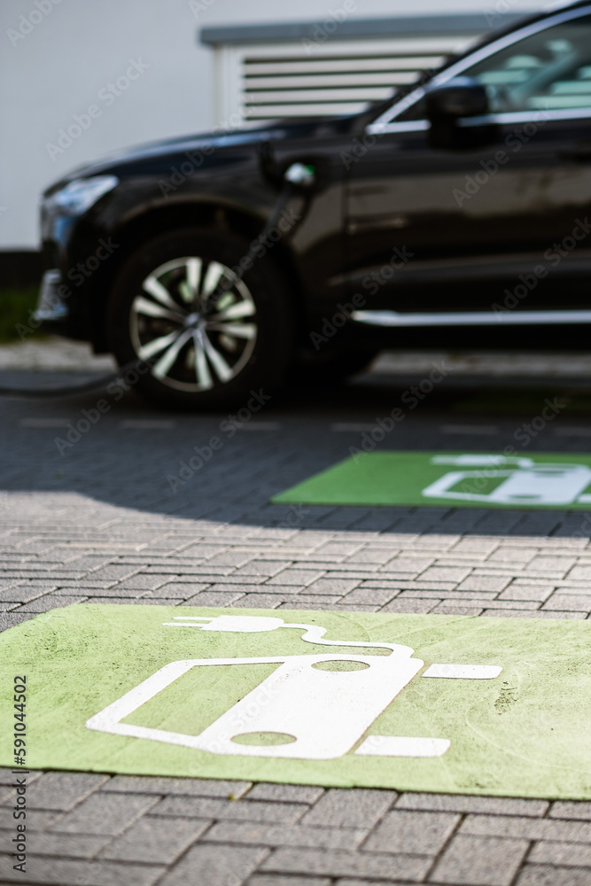 Obraz premium Ein E-Auto lädt an einer öffentlichen Ladestation in Düsseldorf