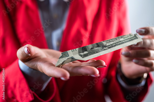 top view of female boss hands holding many cash dollars isolated on plain background.