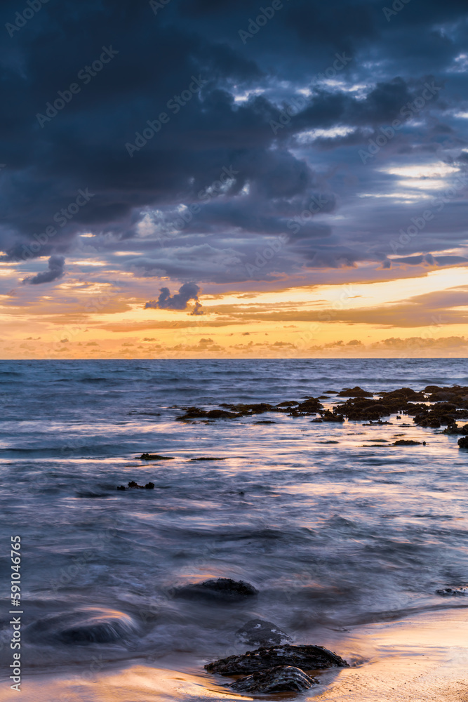 Sunrise with scattered rain clouds at the seaside