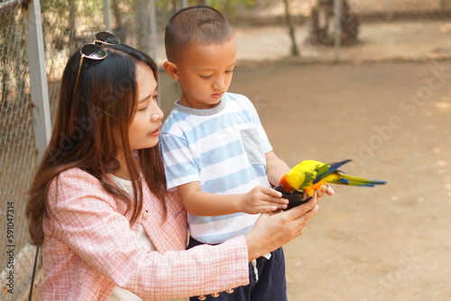 mother and son feeding birds on holiday photo