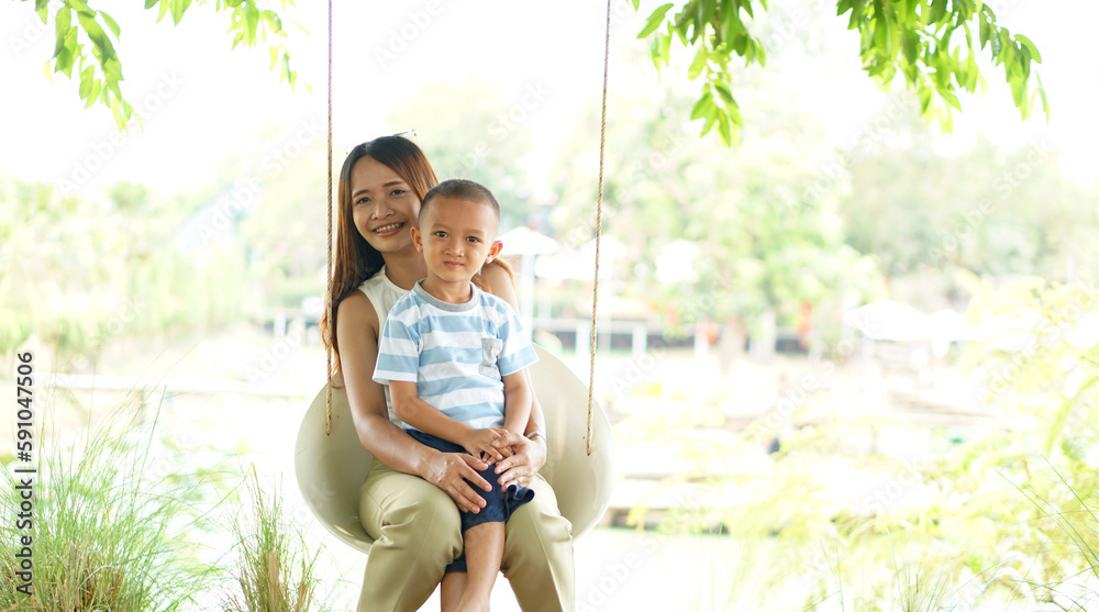 Happy mother and son on the swing in the park Happy mother and son on the swing in the park
