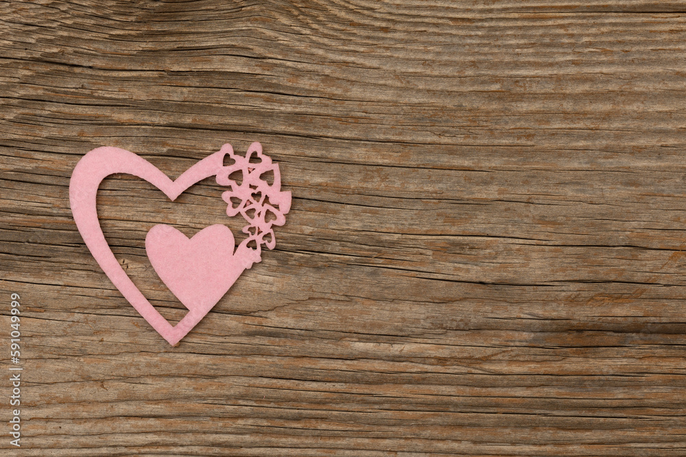 rose-colored playful heart on rustic brown wooden background with free space for text rose-colored playful heart on rustic brown wooden background with free space for text