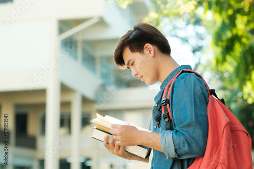 Student standing outdoor and holding books.
