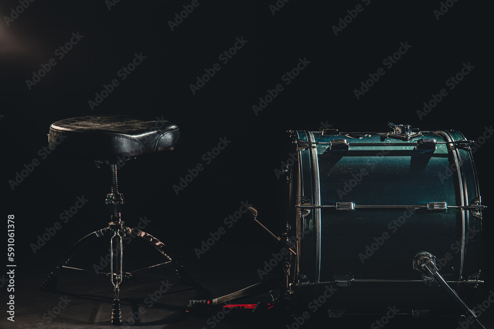 Bass drum and chair on a black background, drummer's seat.