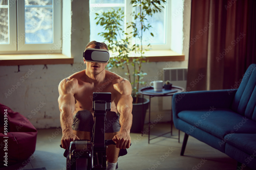 Athletic young shirtless man with relief body training at home, doing ...