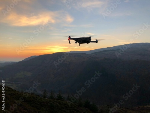 Drone flying over the mountain at sunset.