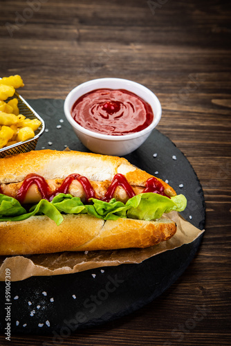 Hot dog  French fries and ketchup on wooden table 