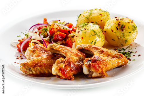 Barbecued chicken wings with boiled potatoes and tomato salad on white background