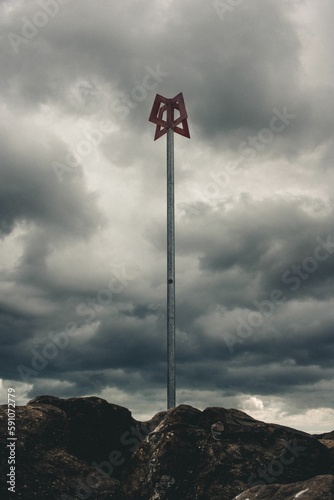 Vertical shot of a metal pole against the background of the cloudy sky.