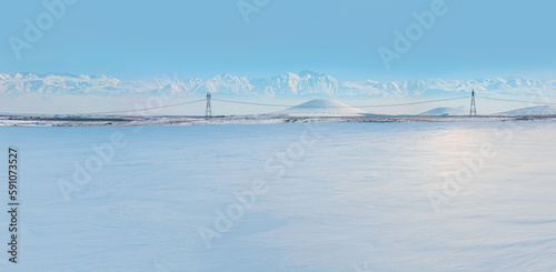 High voltage power lines with  snowy mountains in the background
