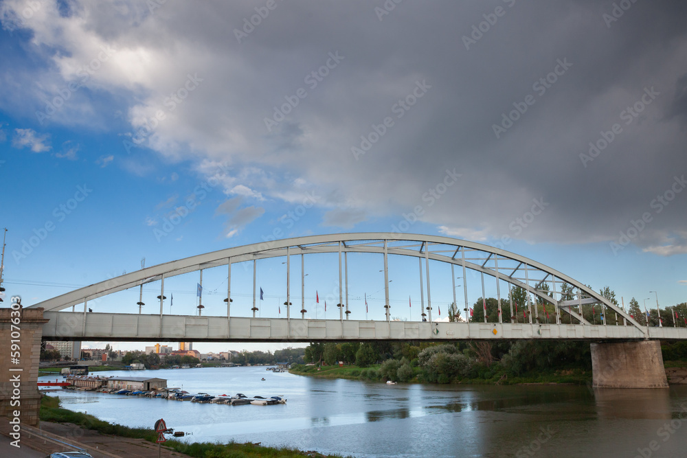 Belvarosi Hid bridge, also known as Downtown bridge on the tisza river during a sunny sunset. The bridge connects the two parts of this city, the main one of Southern Hungary.