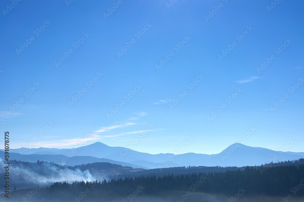 Remote view on mountain ridge in a fog with bright clear sky Remote view on mountain ridge in a fog with bright clear sky