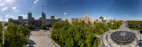 Aerial view on Derzhprom and northern Karazin National University buildings on Freedom Square with circle fountain, spring greenery and blue sky in Kharkiv, Ukraine