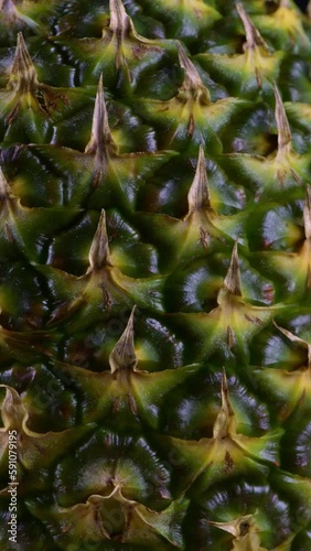 A close-up of a rotating pineapple in vertical video.