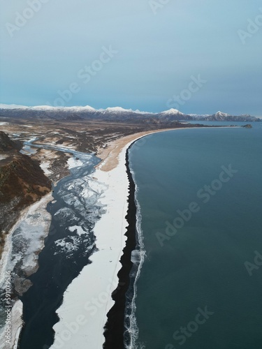 Wallpaper Mural Vertical aerial view of the sea waves splashing over the bay covered in snow perfect for wallpapers Torontodigital.ca